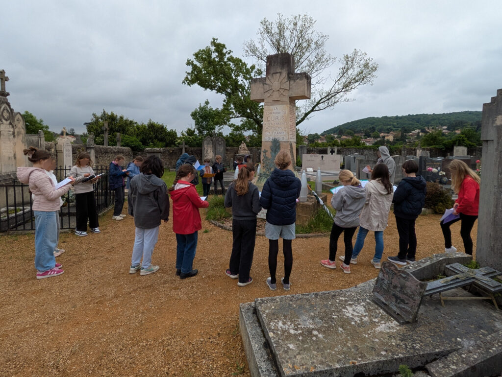 Une classe d'enfants autour d'un monument aux morts