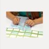 Un enfant place les post-its de l’arbre généalogique sur une feuille, dans un tableau