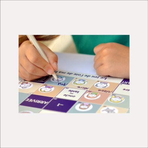 un enfant écrit le prénom d’un individu sur le plateau de jeu